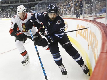 The Senators' Dion Phaneuf covers the Jets' Mathieu Perreault.
