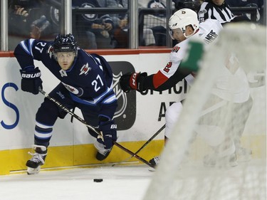 The Winnipeg Jets' Nikolaj Ehlers drives out of the corner as the Ottawa Senators' Dion Phaneuf defends.