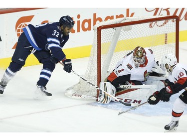 The Winnipeg Jets' Dustin Byfuglien attempts the wraparound on Ottawa Senators goaltender Mike Condon.