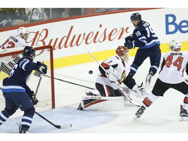 The Winnipeg Jets' Nic Petan attempts the backhanded pass to Marko Dano sitting in front of Ottawa Senators goaltender Mike Condon's net as Jean-Gabriel Pageau defends.