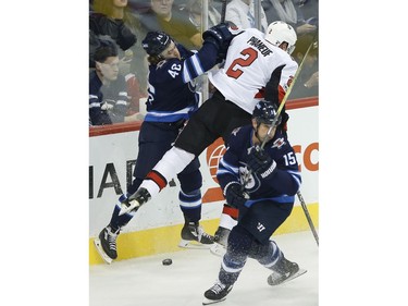 The Winnipeg Jets' JC Lipon (46) and the Ottawa Senators' Dion Phaneuf collide as the Jets' Matt Hendricks skates by.