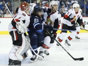 The Winnipeg Jets' Mathieu Perreault attempts to get between Ottawa Senators goaltender Mike Condon and Fredrik Claesson.