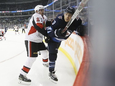 The Ottawa Senators' Dion Phaneuf checks the Winnipeg Jets' Brandon Tanev.