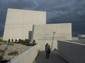 A man stops to take a photo of the Canadian National Holocaust Monument following its official opening ceremony in Ottawa, Wednesday September 27, 2017.