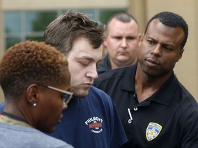 Kenneth James Gleason is escorted by police to a waiting police car in Baton Rouge, La., Tuesday, Sept. 19, 2017. Gleason is charged with two counts of first degree murder and other charges, for three shootings in the Baton Rouge area throughout the past week that resulted in the death of two men. (AP Photo/Gerald Herbert)