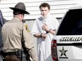 Wearing a hospital gown and neck brace, Zachary Wittke is led into a Franklin County Sheriff transport vehicle in 2013.
