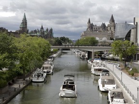 A cruiser navigates between boats and cruisers moored along the Rideau Canal in downtown Ottawa, ON.