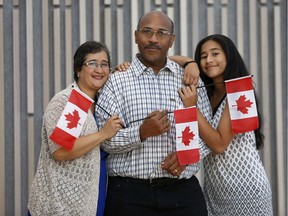 New Canadians Aida Castillo, Duane Omeir and Melissa Omeir (13) get a photo taken after becoming Canadian citizens an citizenship ceremony at the National Arts Centre (NAC) in Ottawa Ontario Monday Sept 25, 2017.