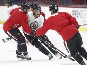 Logan Brown, in white, attempts to get around Bobby Ryan, with Thomas Chabot waiting ahead during practice at the Canadian Tire Centre on Wednesday, Sept. 27, 2017.