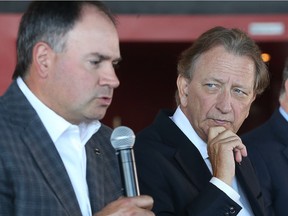 Senators owner Eugene Melnyk listens in as general manager Pierre Dorion addresses the media at Canadian Tire Centre on Thursday.  Tony Caldwell/Postmedia