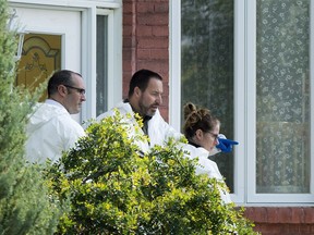 Police forensic investigators a home in Saint-Eustache, Que., Friday, Sept. 15, 2017, where a woman was found dead and her six-year-old boy missing.