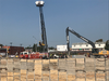 Firefighters lower the Stokes basket stretcher to pick up an injured worker at a construction site.