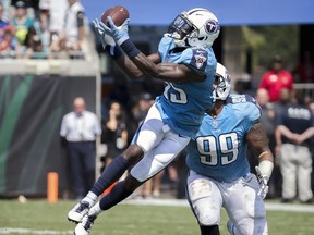 Tennessee Titans cornerback Curtis Riley, left, intercepts a Jacksonville Jaguars pass in front of teammate defensive end Jurrell Casey (99) during the first half of an NFL football game in Jacksonville, Fla., Sunday, Sept. 17, 2017.