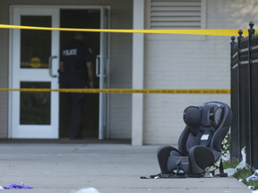 A car seat sits behind police tape where a toddler was removed from the back seat of a hot car in Toronto on Thursday. The young boy later died in hospital.