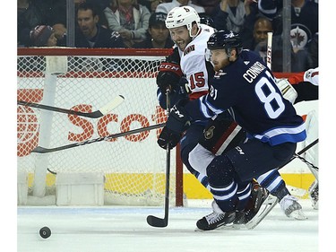 Winnipeg Jets forward Kyle Connor and Ottawa Senators forward Zach Smith eye a loose puck.
