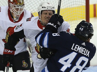 Winnipeg Jets forward Brendan Lemieux (right) catches Ottawa Senators defenceman Dion Phaneuf with a glove in the face.