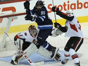 Winnipeg Jets forward Mathieu Perreault jumps in front of Ottawa Senators goaltender Mike Condon as Fredrik Claesson defends on Wednesday, Sept. 27, 2017.