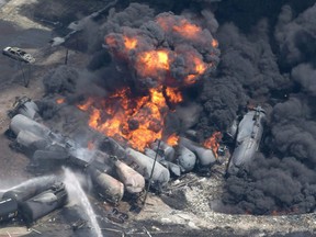 Smoke rises from railway cars that were carrying crude oil after derailing in downtown Lac-Mégantic, Que., Saturday, July 6, 2013. A half-dozen people have so far been selected to sit as jurors for the criminal case of the 2013 Lac-Megantic train derailment that killed 47 people and destroyed part of the town.