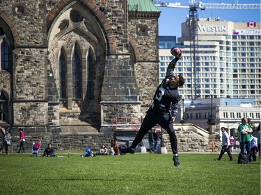 The Saskatchewan Roughriders held a practice on Parliament Hill Sunday October 1, 2017 in Ottawa, after playing the Redblacks Friday night. Vernon Adams Jr. jumps to catch the ball.   Ashley Fraser/Postmedia
