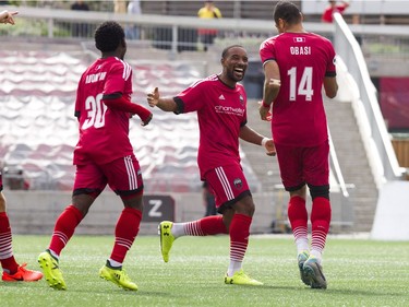 Ottawa's Adonijah Reid (30) and Jamar Dixon congratulate Onua Thomas Obasi after he scored early in the first half.   Ashley Fraser/Postmedia