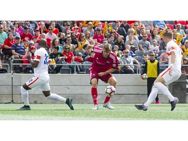 Ottawa's Nick DePuy tries to keep the ball from FC Cincinnati defenders.   Ashley Fraser/Postmedia