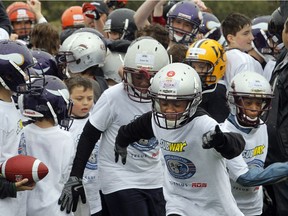 OTTAWA, ON. MAY 14, 2011 --- The Montreal Alouettes held a football clinic for about 130 local Ottawa/Gatineau kids at Stade du Complexe sportif Mont-Bleu in Gatineau Saturday. Here, all 130 kids who attended the clinic pelt from the rain-soaked field for lunch.