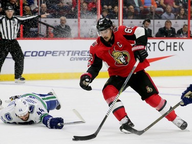 Ottawa's captain Erik Karlsson (centre) gets past Vancouver to bring the puck to the net during first-period action between the Ottawa Senators (red) and the Vancouver Canucks Tuesday (October 17, 2017) at Canadian Tire Centre. Julie Oliver/Postmedia