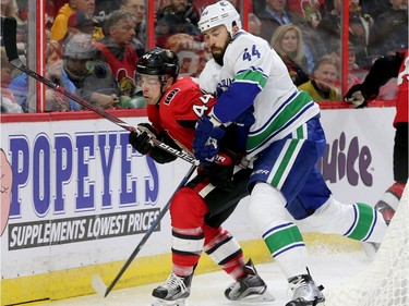 Ottawa's Jean Gabriel Pageau (left) battles for the puck with Erik Gudbranson behind Vancouver's net during first-period action between the Ottawa Senators (red) and the Vancouver Canucks Tuesday (October 17, 2017) at Canadian Tire Centre. Julie Oliver/Postmedia