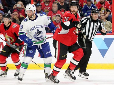 Zack Smith (right) keeps an eye on the puck as he breaks past Vancouver's Sam Gagner during first-period action between the Ottawa Senators (red) and the Vancouver Canucks Tuesday (October 17, 2017) at Canadian Tire Centre.