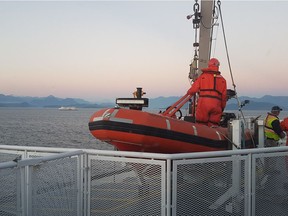 BC Ferries crewmembers prepare to launch a rescue boat after a person fell overboard on the Queen of Cowichan on Monday at about 5:45 p.m. The Queen of Cowichan can be seen in the distance.