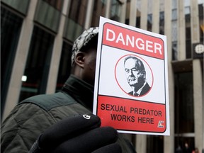 A demonstrator holds a sign outside News Corp., in New York City, where TV personality Bill O'Reilly once worked.