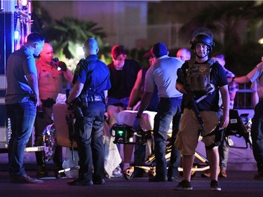 Police officers stand by as medical personnel tend to a person on Tropicana Ave. near Las Vegas Boulevard after a mass shooting at a country music festival nearby on October 2, 2017 in Las Vegas, Nevada .A gunman has opened fire on a music festival in Las Vegas, leaving over 20 people dead. Police have confirmed that one suspect has been shot. The investigation is ongoing.