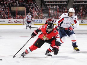 Johnny Oduya (29) of the Senators knocks the puck away from Alex Ovechkin of the Capitals in the first period of Thursday's season opener.  Jana Chytilova/Getty Images