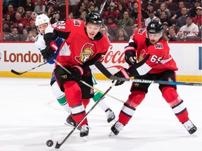 Erik Karlsson #65 of the Ottawa Senators clears the puck up to team mate Mark Borowiecki #74 as Derek Dorsett #15 of the Vancouver Canucks looks on in the first period at Canadian Tire Centre on October 17, 2017 in Ottawa, Ontario, Canada.  (Photo by Jana Chytilova/Freestyle Photography/Getty Images)