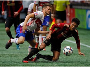 Eriq Zavaleta of Toronto FC challenges Yamil Asad of Atlanta United at Mercedes-Benz Stadium on Sunday.  Kevin C. Cox/Getty Images