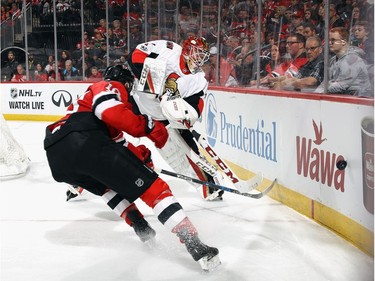Senators goalie Mike Condon shoots the puck away from the onrushing Jimmy Hayes of the Devils during the second period.  Bruce Bennett/Getty Images