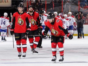 While Canadiens players celebrate Monday's victory i the background, Senators players skate slowly off the ice at Canadian Tire Centre, including, left to right, Ryan Dzingel, Zack Smith and Chris DiDomenico.