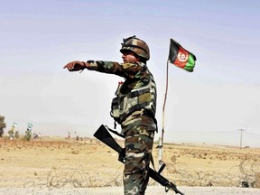 An Afghan National Army soldier directs a vehicle to stop at a checkpoint on the way to Zhari district, where the Maiwand army base is located, in Kandahar, Afghanistan, Thursday, Oct. 19, 2017.