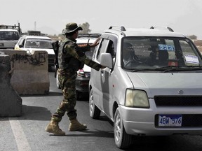 An Afghan National Army soldier searches a vehicle at a checkpoint on the way to Zhari district, where the Maiwand army base is located, in Kandahar, Afghanistan, Thursday, Oct. 19, 2017. The Taliban have killed at least 58 Afghan security forces in a wave of attacks across the country, including an assault that nearly wiped out the Maiwand camp in the southern Kandahar province.
