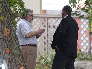 Patrick Boyle, left, father of Joshua Boyle, speaks with security outside his house in Smiths Falls on Saturday, Oct. 14, 2017.