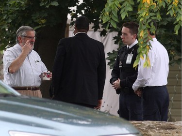 Patrick Boyle, left, father of Joshua Boyle, speaks with security outside his house in Smiths Falls on Saturday, Oct. 14, 2017.