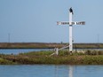 A cross stands at the mouth of the harbor reading "Jesus is Life" in Tangier, Virginia, May 16, 2017, where climate change and rising sea levels threaten the inhabitants of the slowly sinking island.