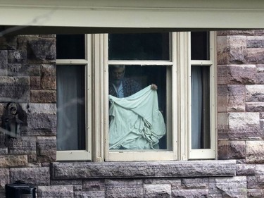 Patrick Boyle, father of freed Canadian hostage Joshua Boyle, puts up a bedsheet to block the view of journalists camped outside the Boyle family home in Smiths Falls on October 14, 2017.