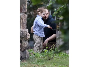 Freed Canadian hostage Joshua Boyle watches as his son, Jonah, plays outside his parents' home in Smiths Falls on Saturday, Oct. 14, 2017.