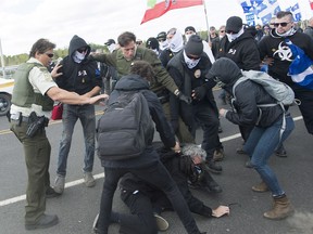 Provincial police intervene as opposing protesters clash during a demonstration in Lacolle, Que., Saturday, September 30, 2017. THE CANADIAN PRESS/Graham Hughes