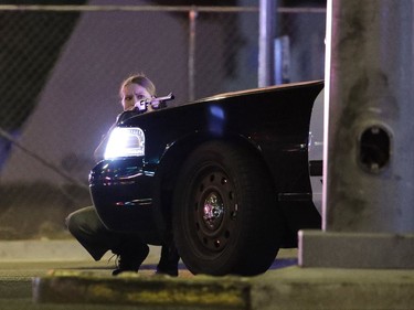 A police officer takes cover behind a police vehicle during a shooting near the Mandalay Bay resort and casino on the Las Vegas Strip, Sunday, Oct. 1, 2017, in Las Vegas.