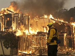 Wildfires whipped by powerful winds swept through Northern California sending residents on a headlong flight to safety through smoke and flames as homes burned.