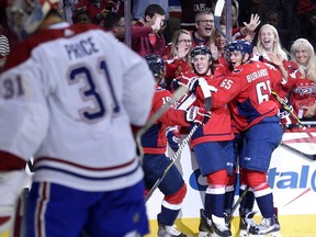 Washington Capitals' T..J. Oshie, second from right, celebrates his goal with Andre Burakovsky (65) and others as Canadiens goalie Carey Price looks away during the first period of a NHL hockey game on Saturday, Oct. 7, 2017, in Washington.