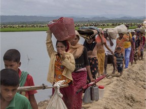 Rohingya Muslims, who crossed over from Myanmar walk towards refugee camps after spending four days in the open, having being earlier prevented by Bangladesh border guards from moving ahead, at Palong Khali, Bangladesh, Thursday, Oct. 19, 2017.