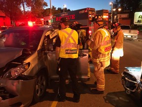 Emergency personnel work to free a taxi driver early Friday. The driver suffered minor injuries.